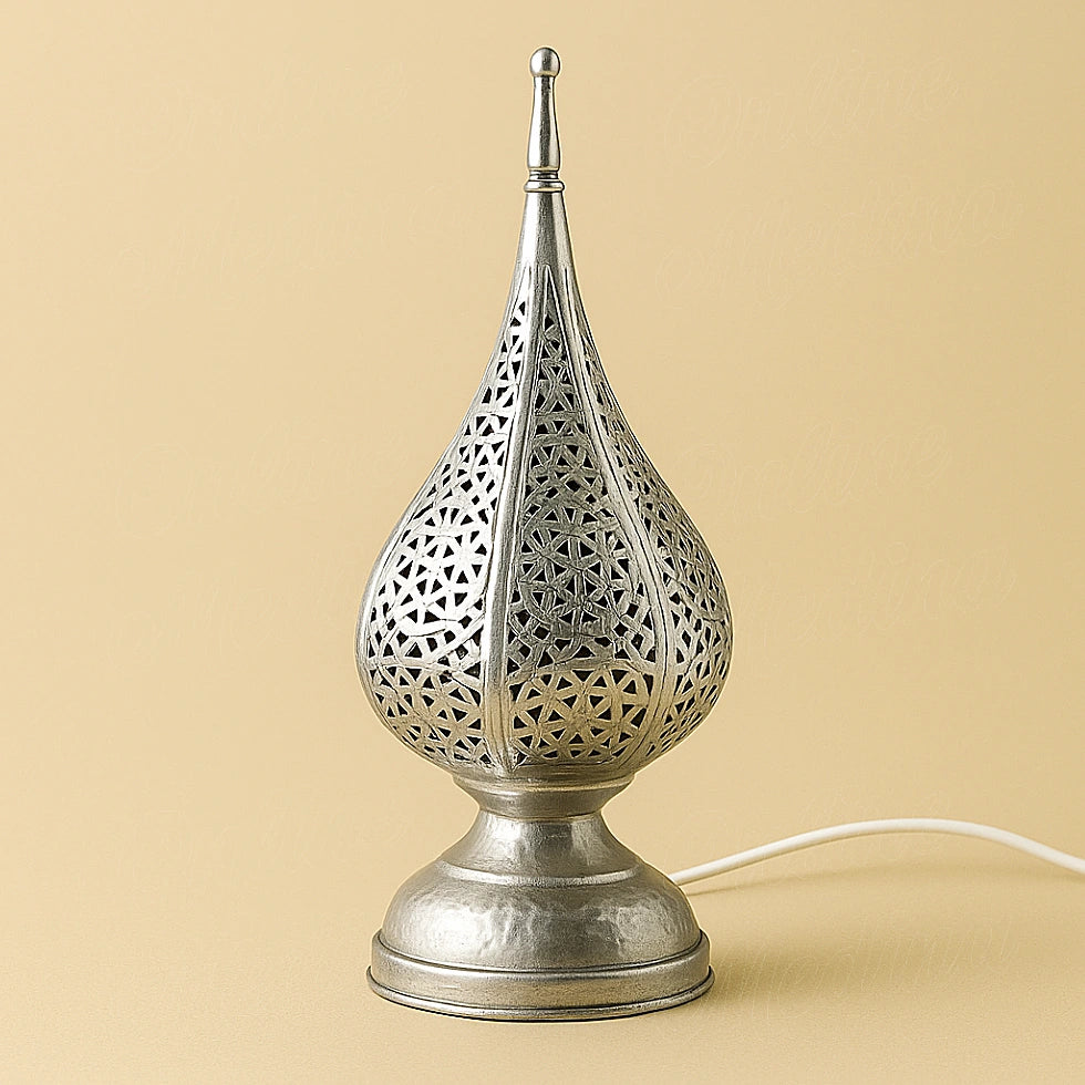Silver tear-drop Moroccan lamp with hammered geometric pattern, handcrafted metalwork on neutral beige background