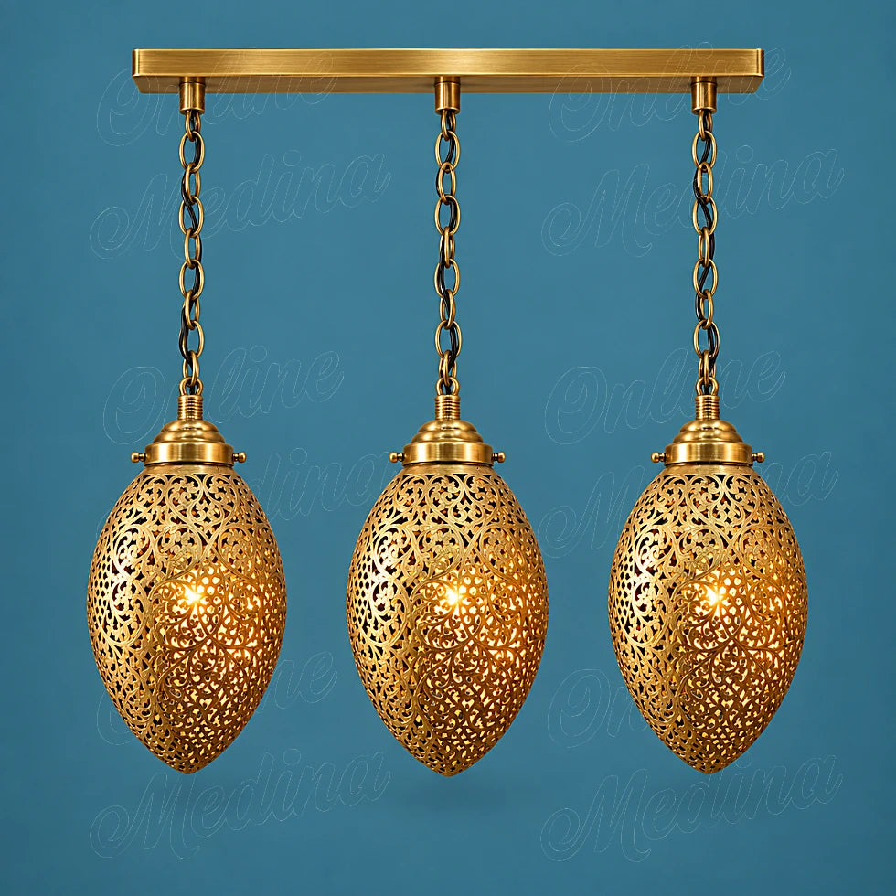 Three glowing openwork brass ovoid pendants on a rectangular canopy against a blue background