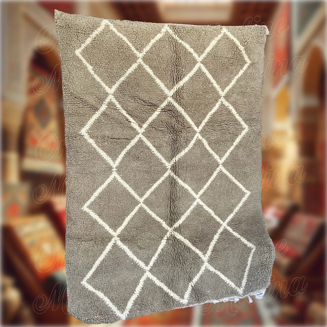 Tapis Beni Ouarain artisanal en laine grise avec motifs en losanges blancs, fabriqué à la main au Maroc, idéal pour une décoration intérieure chaleureuse et authentique.
