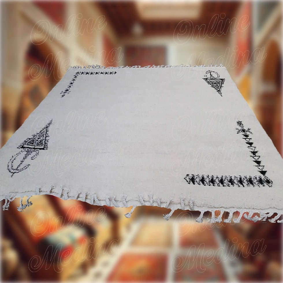 Large handcrafted Moroccan Khelala rug in white wool with black Berber motifs — perfect for warm and elegant ambiance.