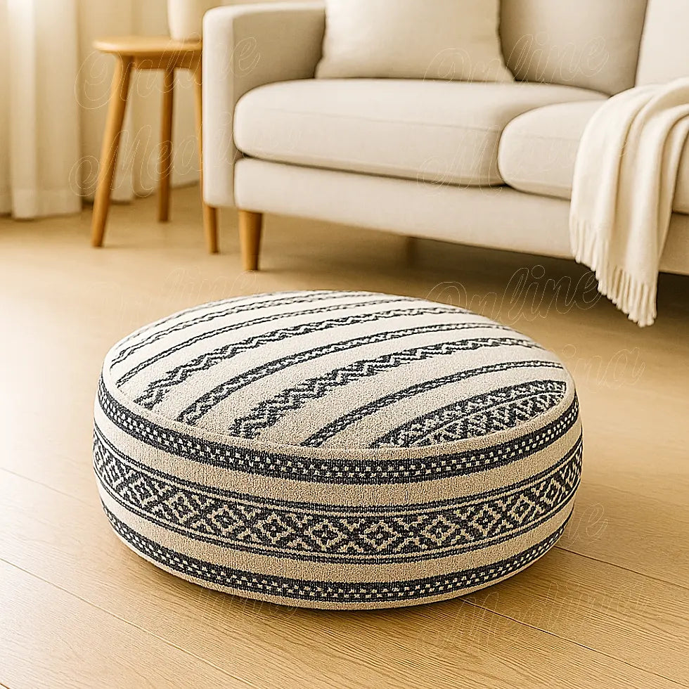 Round Moroccan pouf with geometric black and white patterns, handwoven wool, displayed in a minimalist European living room with beige decor and natural light.