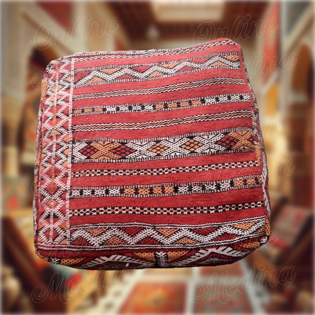 Pouf carré artisanal en Hanbel rouge, fabriqué à la main à partir de laine et de coton, avec motifs berbères traditionnels, parfait pour une décoration élégante et moderne.