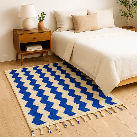 A handwoven Moroccan wool rug featuring bold blue zigzag patterns on a natural beige base, crafted by artisans in the Beni Mellal region for a modern yet authentic home decor.