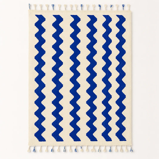 A handmade Moroccan wool rug with elegant blue wave motifs on a neutral wool base, ethically woven by artisans from Beni Mellal.