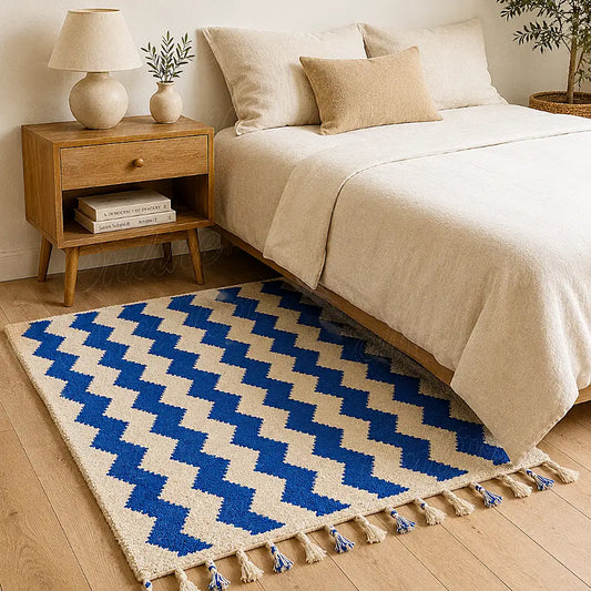 A handwoven Moroccan wool rug featuring bold blue zigzag patterns on a natural beige base, crafted by artisans in the Beni Mellal region for a modern yet authentic home decor.