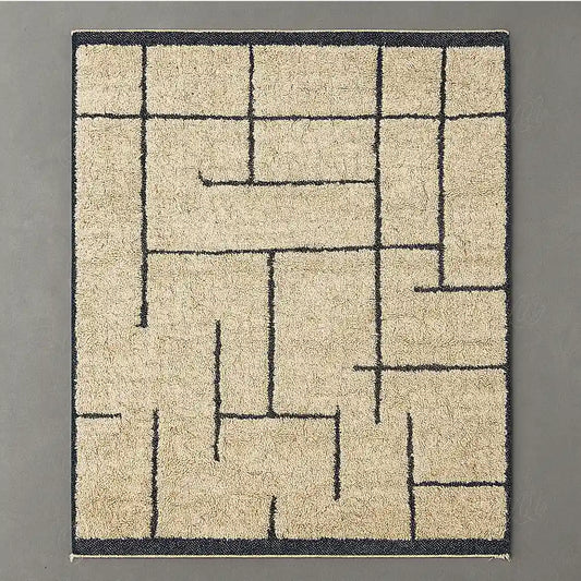 Modern Berber rug in natural wool with black geometric lines on a light beige background.