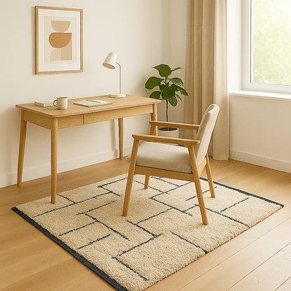 Beige Moroccan wool rug with fine black lines placed under a light wood desk.