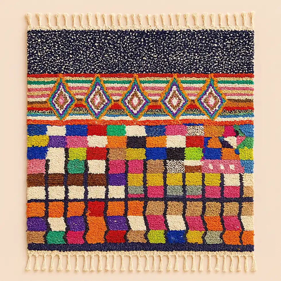 Studio shot of a Boujaad rug with Sahara-inspired geometric patterns and fringes displayed on a clean neutral background