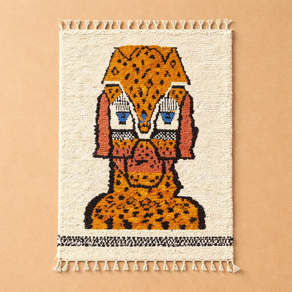Handmade Moroccan rug with animal motif photographed on a plain background