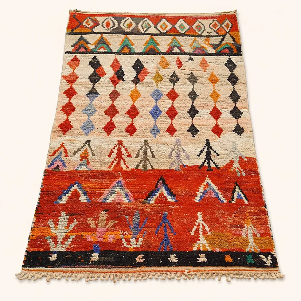 Handmade Moroccan Azilal rug from Beni Mellal featuring red, blue and black tribal patterns on a neutral background