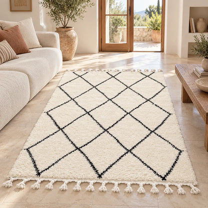 Alfombra de lana cruda con rombos negros frente a un sillón claro, en un salón luminoso con plantas