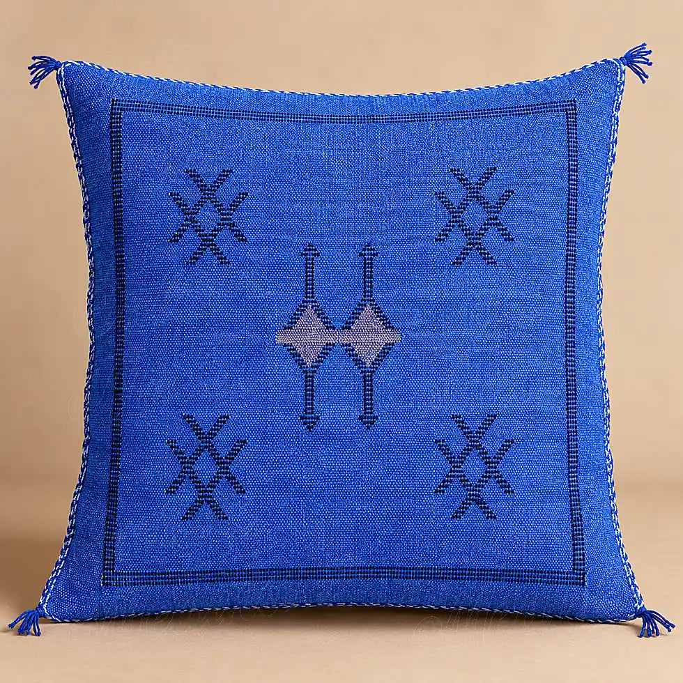 Coussin sabra bleu à motifs croisés présenté seul sur fond beige