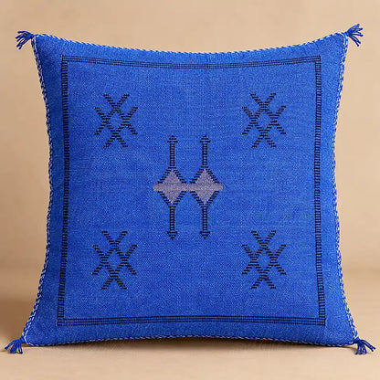 Coussin sabra bleu à motifs croisés présenté seul sur fond beige