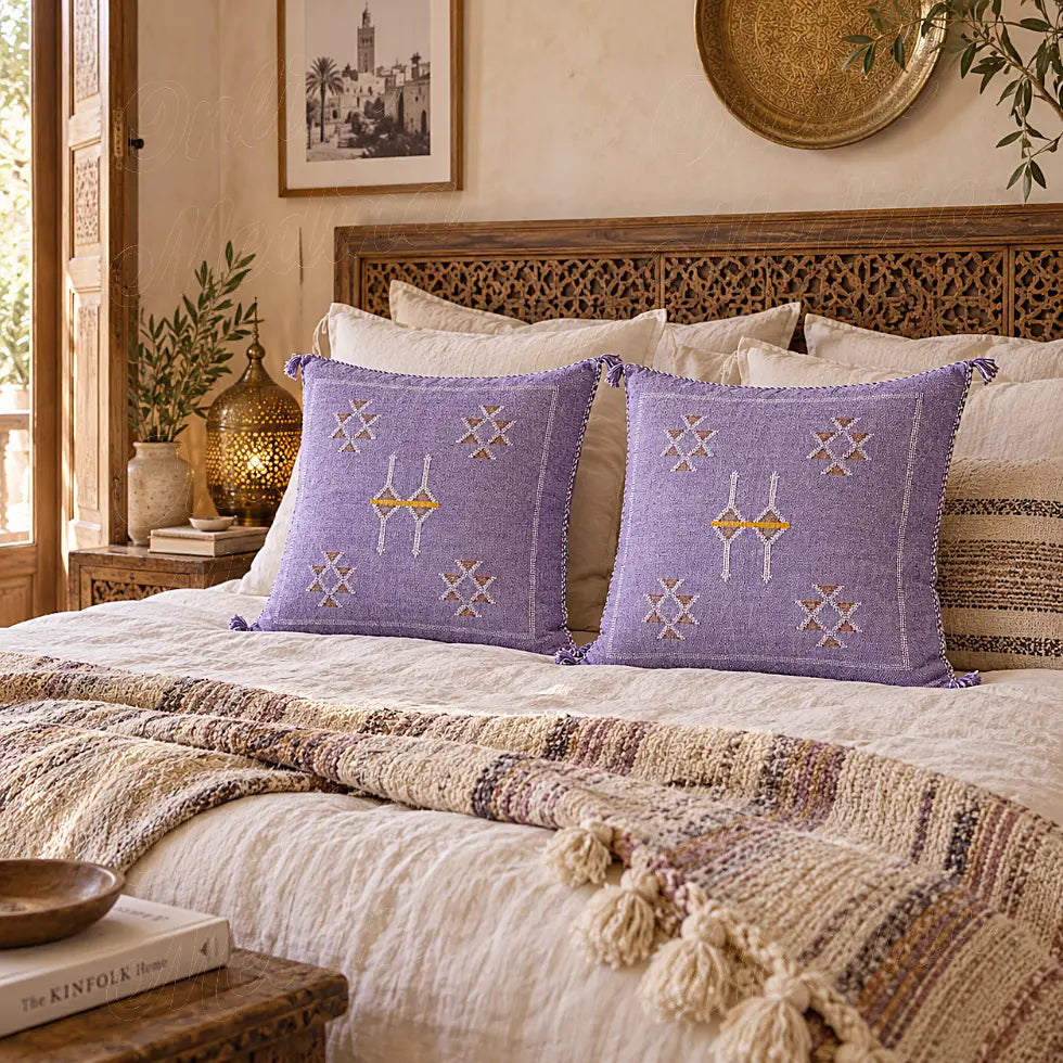 Deux coussins sabra lilas à motifs croisés disposés sur un grand lit