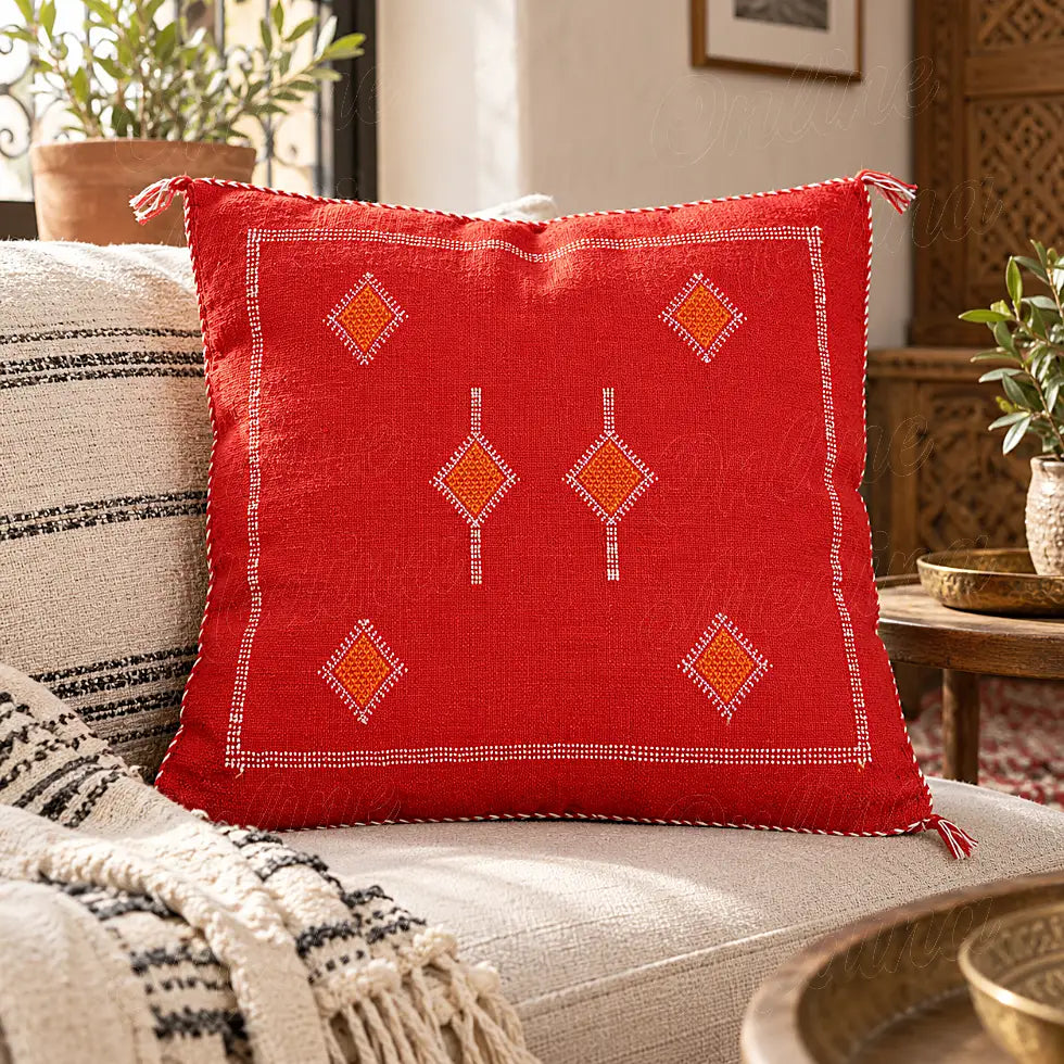 Coussin sabra rouge à losanges orange minimalistes sur un canapé clair