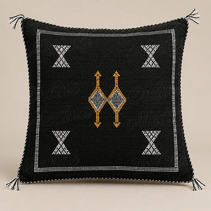 Coussin sabra noir à motifs contrastés sur fond beige uni