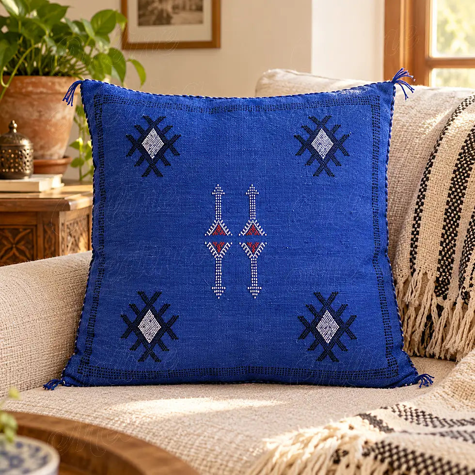 Coussin sabra bleu à motifs angulaires contrastés sur un canapé clair