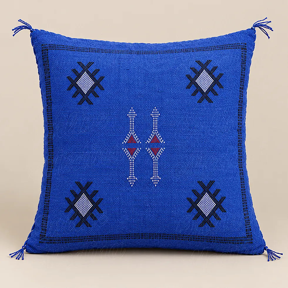 Coussin sabra bleu à motifs contrastés présenté seul sur fond beige