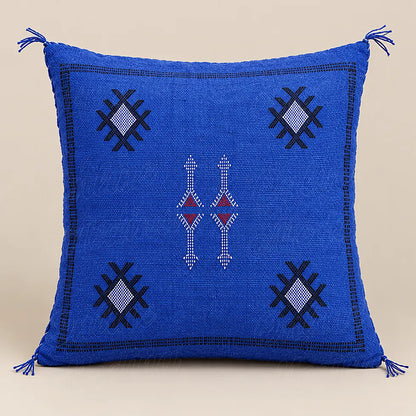 Coussin sabra bleu à motifs contrastés présenté seul sur fond beige