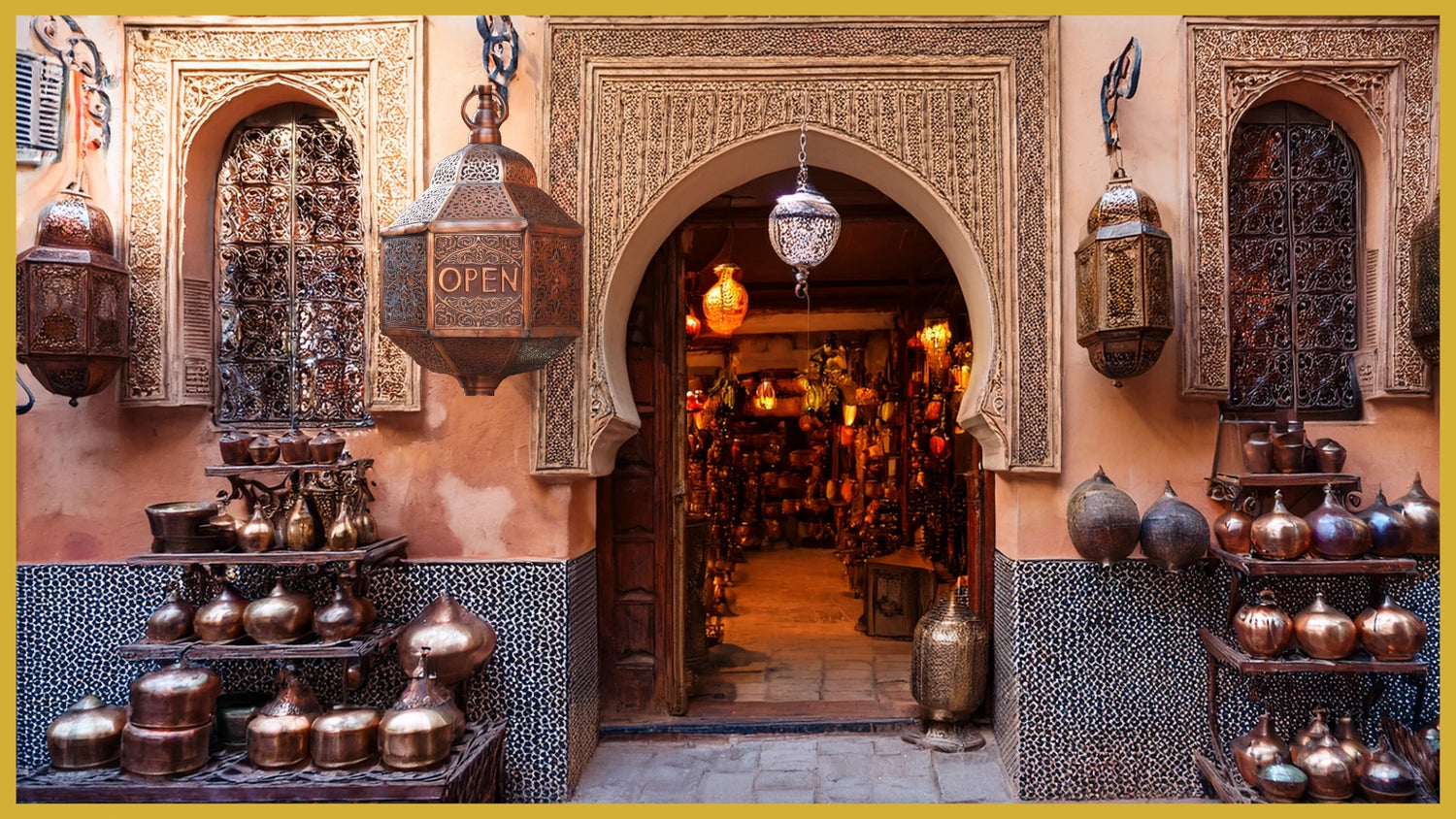 Traditional brassware shopfront in Marrakech displaying Moroccan lanterns, copper vases, and artisanal decor under a zellige arch.