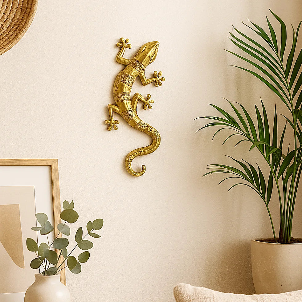 Handcrafted golden brass wall gecko hanging in a minimalist Moroccan-style living room, surrounded by green plants and natural decor elements.