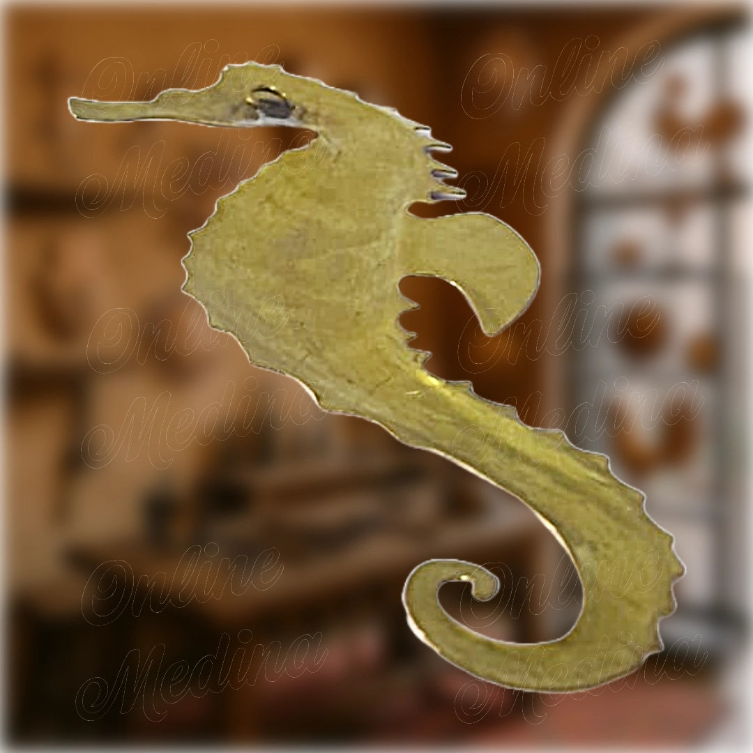 Artisanal Moroccan seahorse wall ornament in raw brass, flat silhouette with cut-out fin and curled tail, made by a master craftsman.