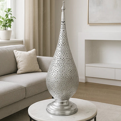 Oriental silver-tin alloy lamp with floral openwork design, softly illuminating a beige European-style living room.