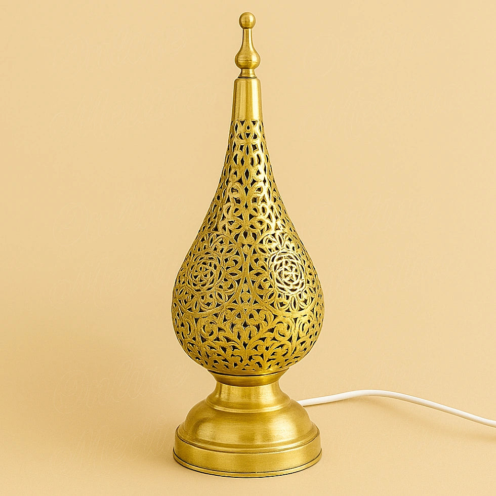 Handcrafted Moroccan brass tear-drop lamp with floral cutout pattern on beige background, made in Marrakech by traditional artisans