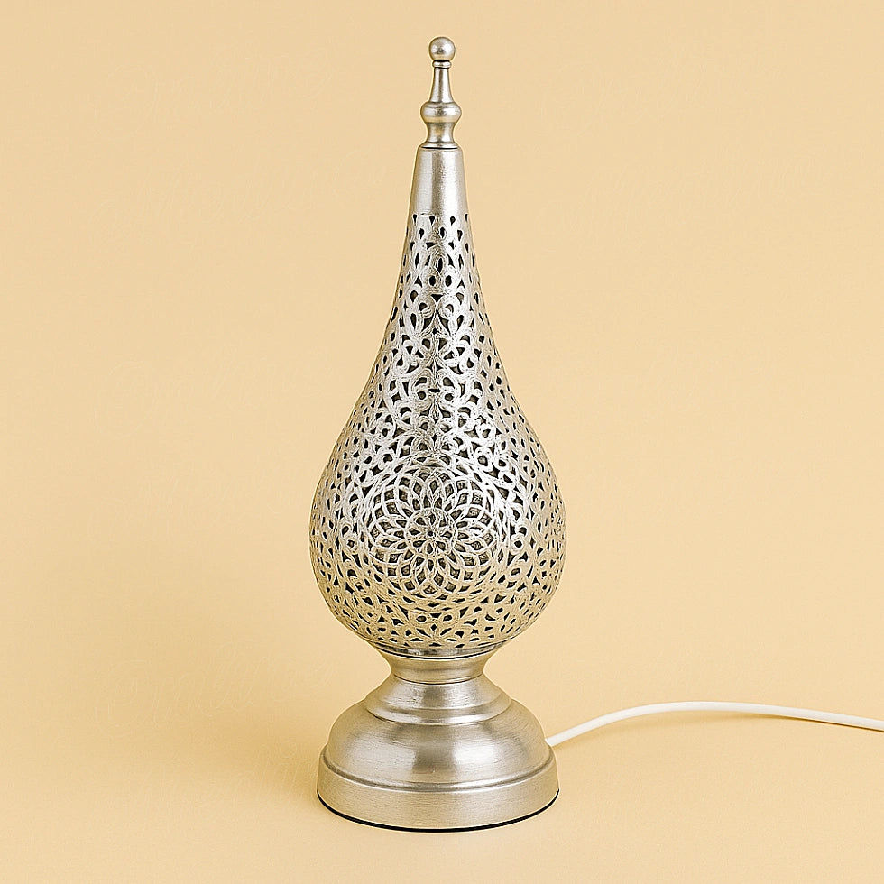 Silver metal tear-drop table lamp with floral Moroccan cutwork design, handcrafted by artisans and photographed on beige studio background
