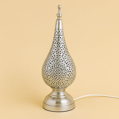 Silver metal tear-drop table lamp with floral Moroccan cutwork design, handcrafted by artisans and photographed on beige studio background