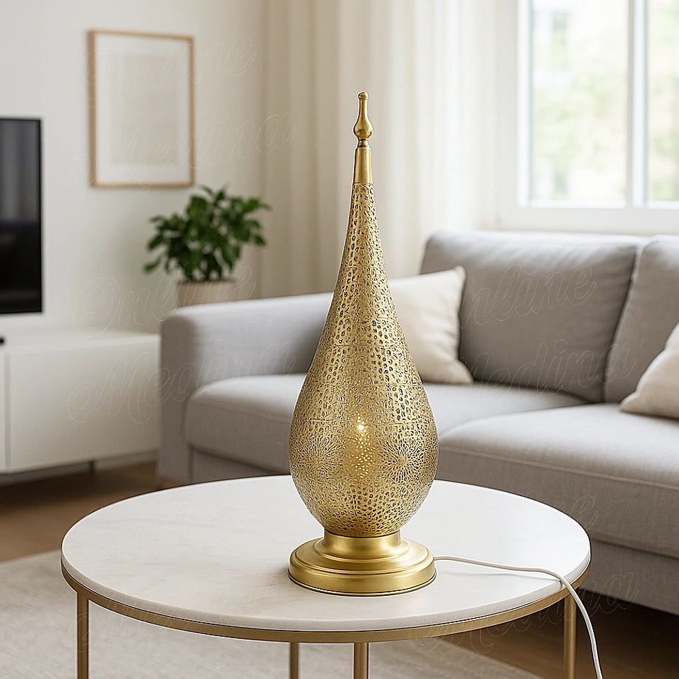 Oriental teardrop brass lamp with intricate cutwork, casting a warm golden glow in a bright modern living room.