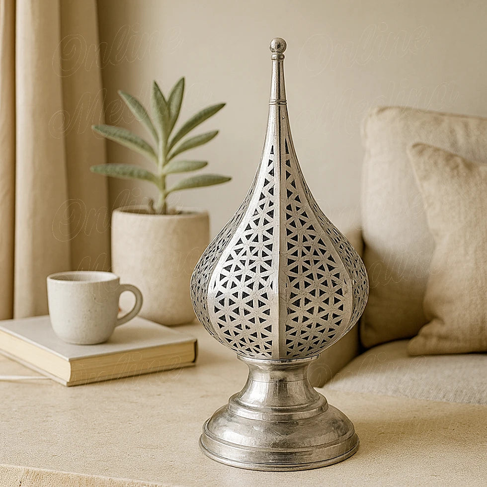 Silver Moroccan geometric lamp on table in cozy living room with plants and cup, handcrafted artisan decor by Online Medina