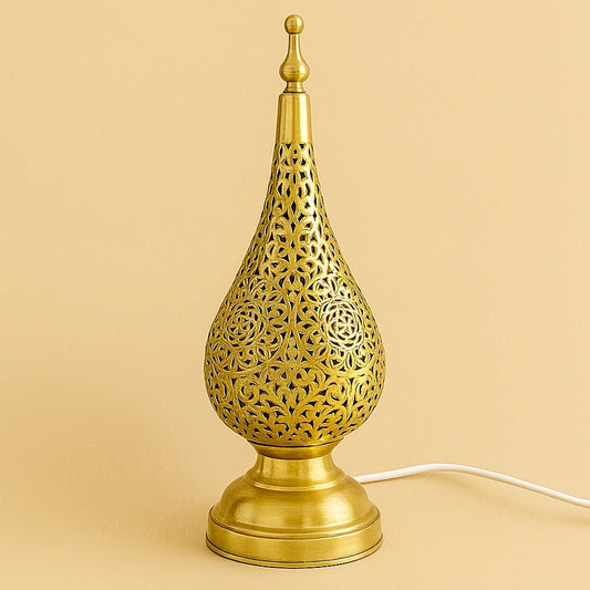 Golden teardrop-shaped metal lamp with rounded openwork patterns, on a pale background with its power cord.