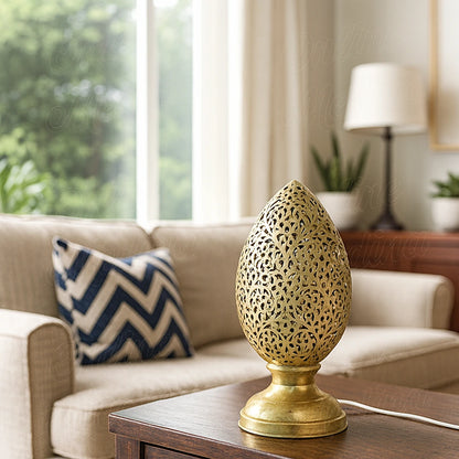 Brass Moroccan flame-shaped perforated lamp on a wooden table in a bright living room – handcrafted home decor