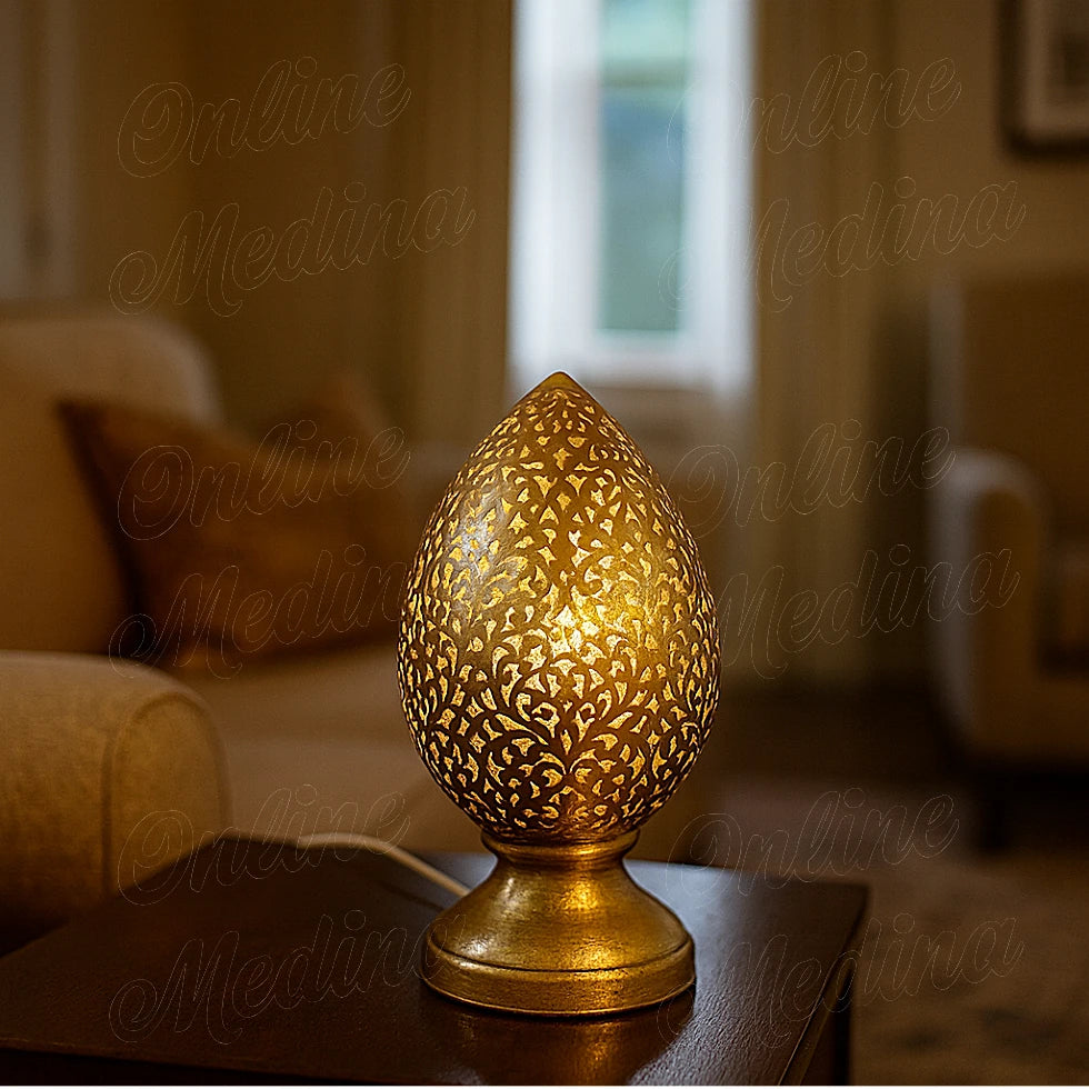 Brass Moroccan flame lamp lit in a cozy dim living room, projecting warm light through floral patterns – Handmade lamp.