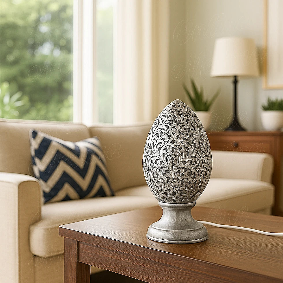 Shiny silver Moroccan perforated egg lamp on a wooden coffee table in a sunlit modern living room – Handcrafted lighting