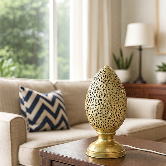 Brass Moroccan flame-shaped perforated lamp on a wooden table in a bright living room – handcrafted home decor