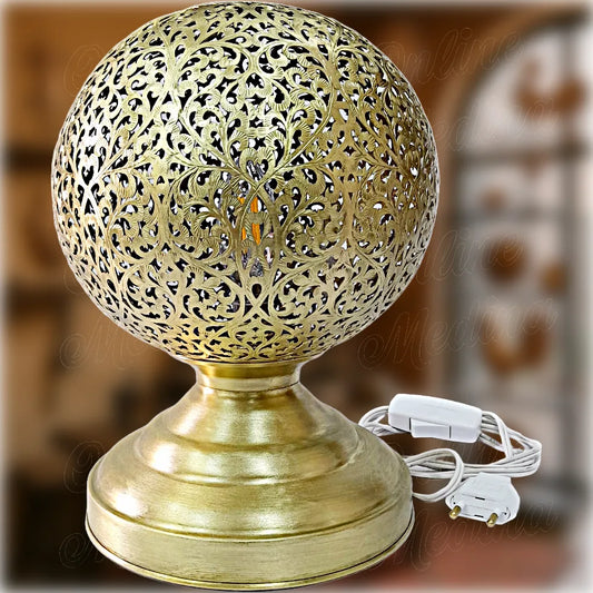 Moroccan artisan globe-shaped brass lamp with filigree floral patterns, hand-pierced and set on a solid rounded base – decorative lighting piece made in Morocco, perfect for bedside or accent tables.
