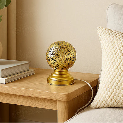 Moroccan brass table lamp with floral openwork pattern on a bedside table