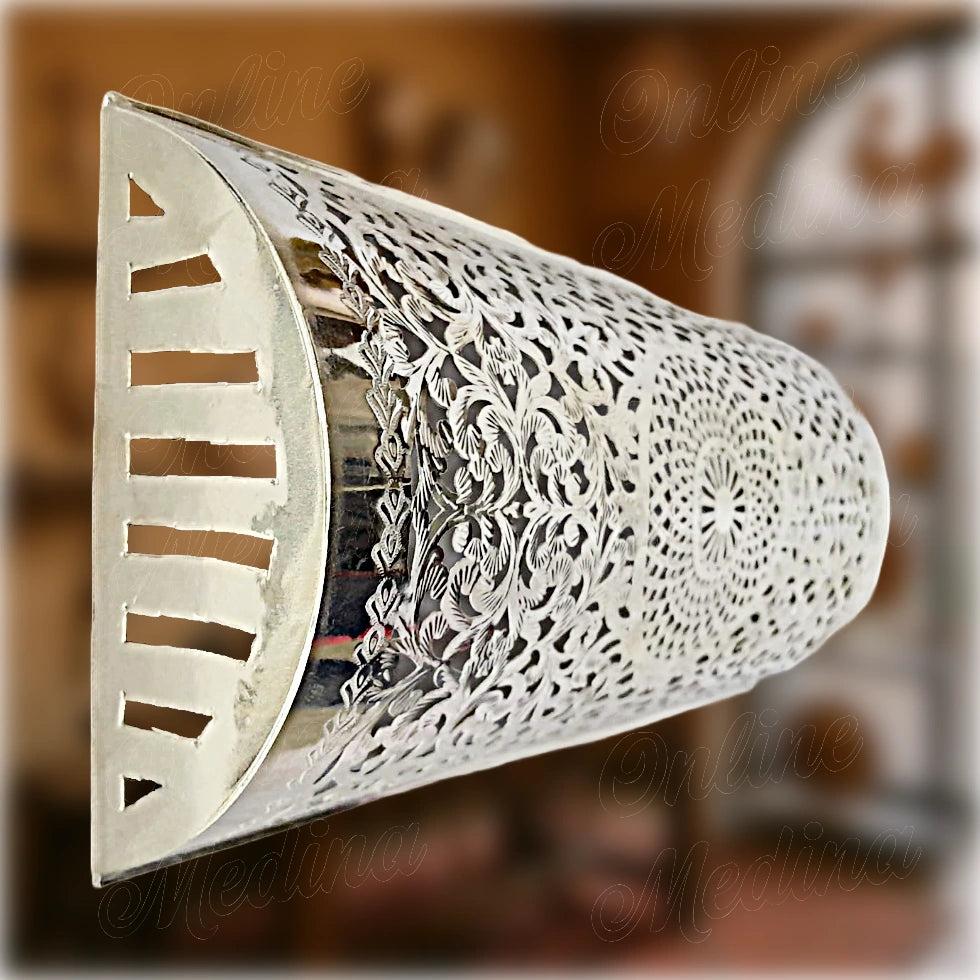 Wall-mounted Moroccan light fixture with semi-cylindrical shape, made from polished metal and adorned with complex lattice motifs – ideal for bedroom or entryway lighting.