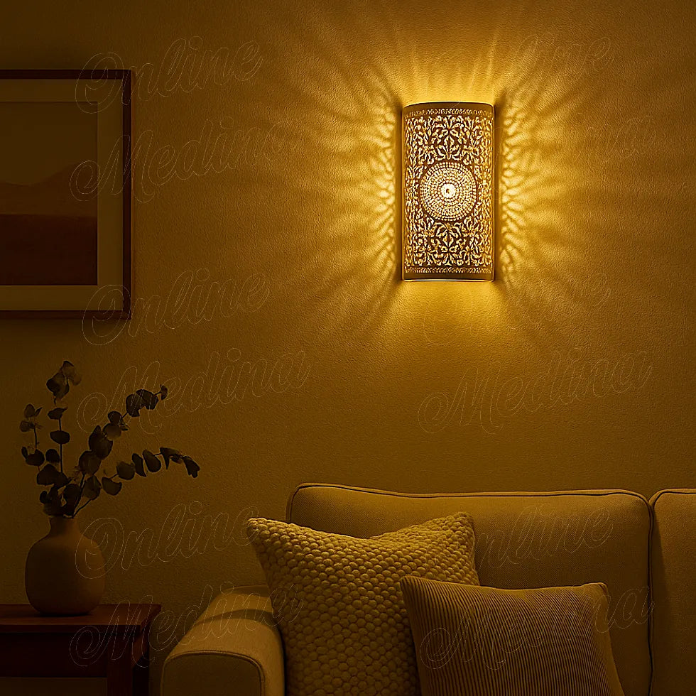 Lit Moroccan brass wall lamp casting warm patterned light on wall in cozy evening living room