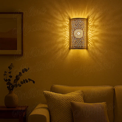 Lit Moroccan brass wall lamp casting warm patterned light on wall in cozy evening living room