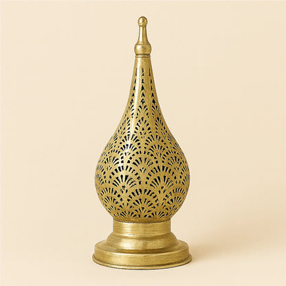 Brass Moroccan candle lantern with oriental openwork design on a plain beige background.