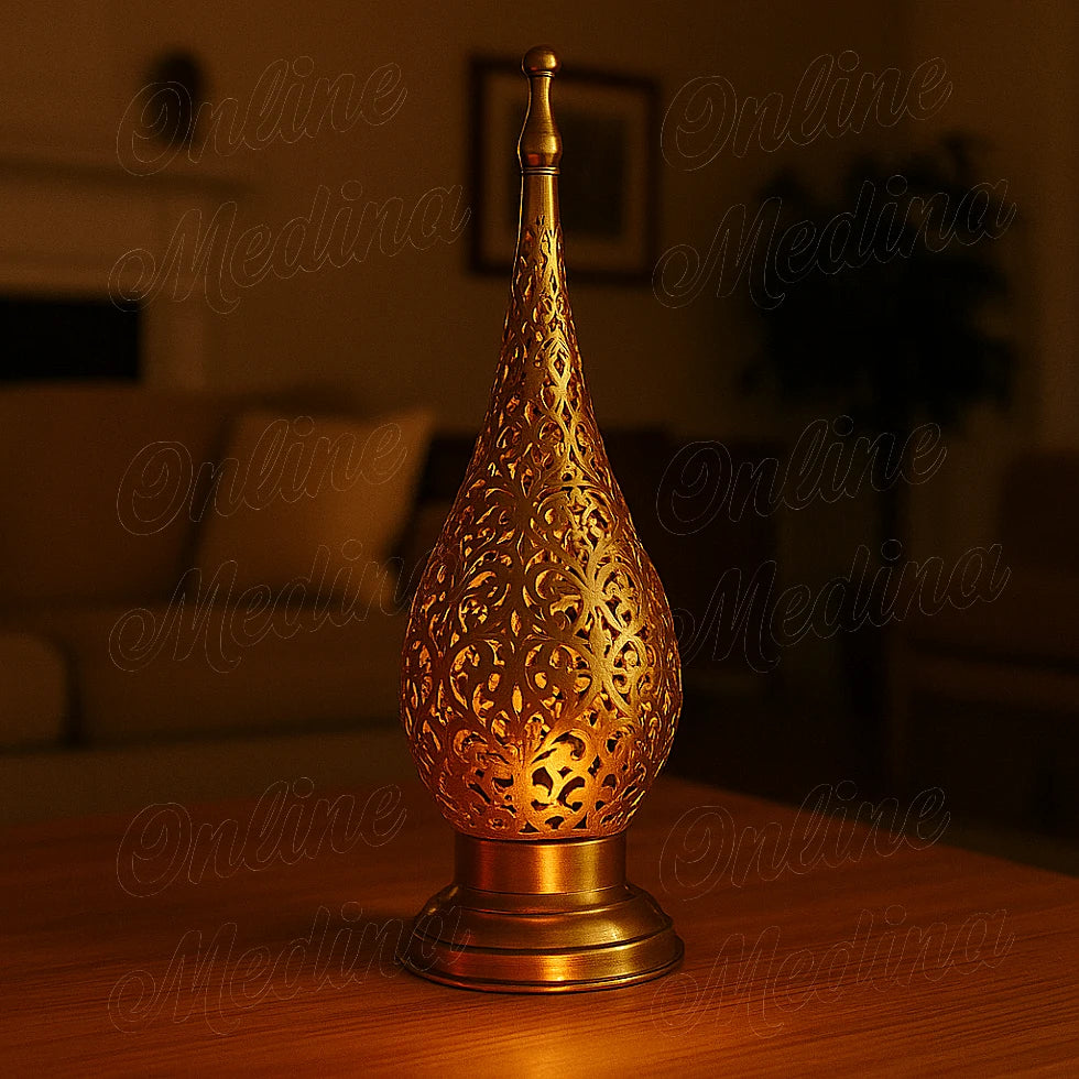 Lit Moroccan brass floral candle lantern glowing warmly in a softly lit living room at night.