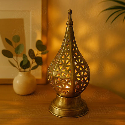 Lit Moroccan brass geometric candle lantern glowing warmly in a softly lit living room at night.