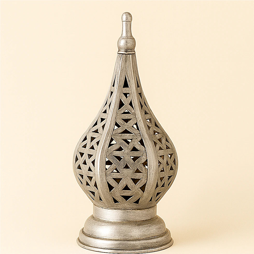 Silver Moroccan geometric candle lantern with detailed triangular openwork on a plain beige background.