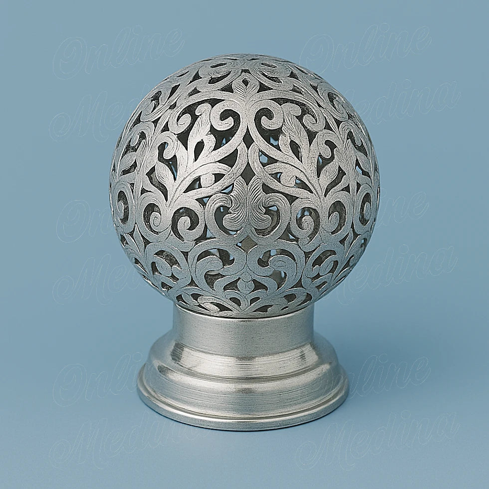 Silver Moroccan spherical candle holder in tin-silver alloy, hand-pierced filigree design on light blue background
