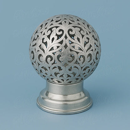 Silver Moroccan spherical candle holder in tin-silver alloy, hand-pierced filigree design on light blue background