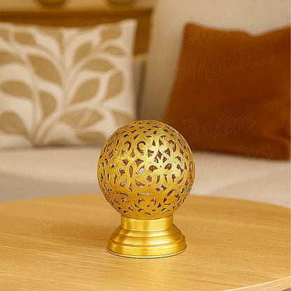 Brass Moroccan candle holder with floral engravings on a coffee table, elegant living room decor