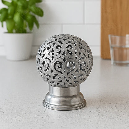 Silver Moroccan candle holder with floral filigree on a kitchen counter, modern home decor